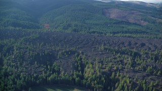 AX154_139 - 5.5K stock footage aerial video flying lava flow and evergreen forest in Parkdale, Oregon