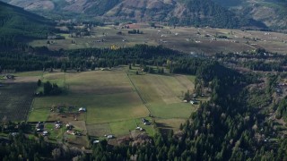 AX154_143E - 5.5K aerial stock footage flying by rural farms and fields in Parkdale, Oregon
