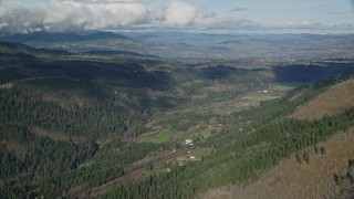 AX154_148 - 5.5K aerial stock footage of farms and evergreen forest in a canyon, Hood River, Oregon