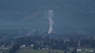 AX154_164 - 5.5K aerial stock footage of smoke rising from a lumber mill in Carson, Washington