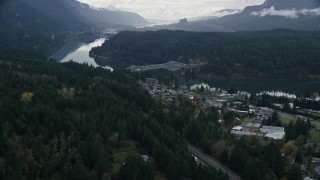 AX154_169E - 5.5K aerial stock footage flying over forest by Interstate 84 to approach Bridge of the Gods, Cascade Locks, Oregon in Columbia River Gorge
