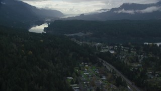 AX154_170 - 5.5K aerial stock footage flying over evergreens by Interstate 84 to approach the Bridge of the Gods, Cascade Locks, Oregon in Columbia River Gorge