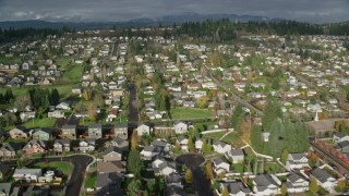 AX154_203 - 5.5K aerial stock footage tilting from the roof of Washougal High School to reveal suburban neighborhoods in Washougal, Washington