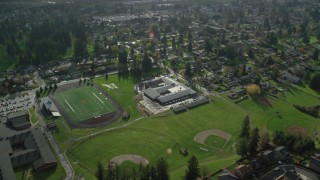 AX154_208 - 5.5K stock footage aerial video orbiting Gause Elementary, Washougal High School, sports fields, and suburban houses in Washougal, Washington