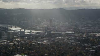 AX154_224 - 5.5K aerial stock footage of godrays shining down on Moda Center, the Willamette River and Downtown Portland, Oregon