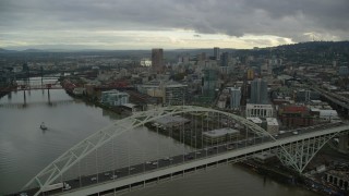 AX155_036 - 5.5K aerial stock footage flying by the Fremont Bridge and focus on skyscrapers in Downtown Portland, Oregon