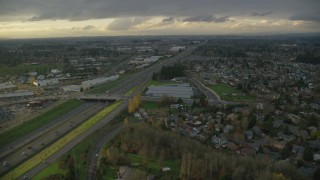 AX155_126 - 5.5K aerial stock footage flying over suburban homes to approach apartment buildings and Highway 26 in Beaverton, Oregon, twilight