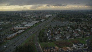 AX155_127 - 5.5K aerial stock footage flying over fly over apartment buildings and follow Highway 26 by Tanasbourne Town Center in Hillsboro, Oregon, twilight