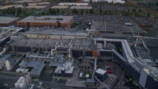 AX155_133 - 5.5K aerial stock footage flying over Intel Ronler Acres Campus at twilight to approach and fly over warehouse buildings, in Hillsboro, Oregon