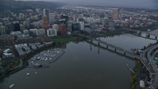 AX155_152E - 5.5K aerial stock footage of riverfront condos, marina and Downtown Portland at twilight, seen from across the Willamette River