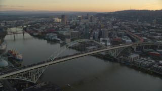 AX155_161 - 5.5K aerial stock footage approaching heavy traffic on the Fremont Bridge at twilight, Downtown Portland in the background, Oregon