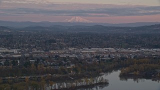 AX155_169 - 5.5K aerial stock footage of Mount Hood in the far distance at twilight, seen from a train yard in Southeast Portland, Oregon