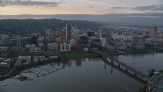 AX155_172E - 5.5K aerial stock footage following the Willamette River over bridges to flyby Downtown Portland at twilight, Oregon