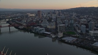 AX155_182E - 5.5K aerial stock footage orbiting the Fremont Bridge with very heavy traffic at twilight, to reveal Downtown Portland, Oregon