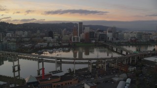 AX155_190 - 5.5K aerial stock footage of Downtown Portland skyline seen while flying by Willamette River bridges at twilight, Oregon
