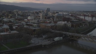 AX155_204 - 5.5K stock footage aerial video flying over Burnside Bridge, and pass the White Stag sign at twilight, Downtown Portland, Oregon