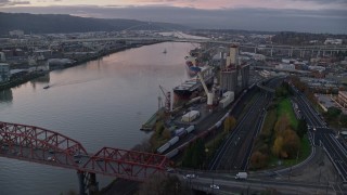 AX155_207 - 5.5K aerial stock footage approaching and fly over a cargo ship and grain elevator at twilight in North Portland, Oregon