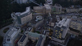 AX155_226E - 5.5K aerial stock footage approaching Oregon Health and Science University in the hills at twilight, Portland, Oregon