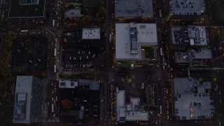 AX155_243E - 5.5K aerial stock footage of a bird's eye view follow SW 5th Avenue at twilight through Downtown Portland, Oregon