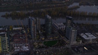 AX155_246E - 5.5K aerial stock footage approaching South Waterfront high-rise condo complexes by the Willamette River in Portland, Oregon, twilight