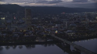 AX155_254 - 5.5K stock footage aerial video of US Bancorp Tower, Burnside Bridge over the Willamette River, and White Stag Sign at twilight, Downtown Portland, Oregon