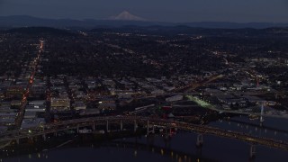 AX155_266 - 5.5K aerial stock footage of Mount Hood in the far distance, and warehouse buildings near the Willamette River, Southeast Portland, Oregon, twilight