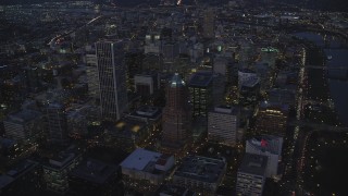 AX155_267 - 5.5K aerial stock footage flying away from KOIN Center and Downtown Portland cityscape beside the Willamette River at twilight, Oregon