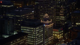 AX155_283 - 5.5K aerial stock footage tracking the top of Jackson Tower at night in Downtown Portland, Oregon