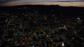 AX155_302E - 5.5K aerial stock footage flying over Downtown Portland at night in Oregon toward skyscrapers