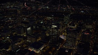 AX155_305E - 5.5K aerial stock footage flying by Park Avenue West Tower and Fox Tower at night in Downtown Portland, Oregon