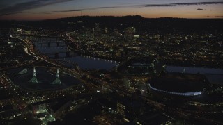 AX155_308 - 5.5K stock footage aerial video of Downtown Portland and Willamette River at night seen from Moda Center in Oregon