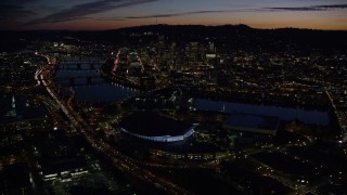 AX155_308E - 5.5K aerial stock footage of Downtown Portland and Willamette River at night seen from Moda Center in Oregon