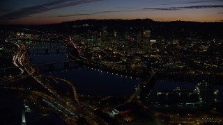 AX155_314E - 5.5K aerial stock footage of a view across the Willamette River of Downtown Portland, Oregon, at night