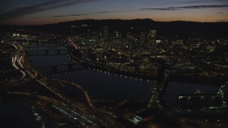 AX155_315 - 5.5K stock footage aerial video of a view across the Willamette River of Downtown Portland, Oregon, at night