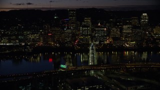 AX155_322 - 5.5K aerial stock footage of Downtown Portland skyscrapers at night across the Hawthorne Bridge spanning Willamette River, Oregon