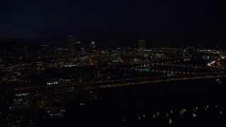 AX155_325E - 5.5K aerial stock footage approaching Marquam Bridge and the Downtown Portland city skyline at night, Oregon
