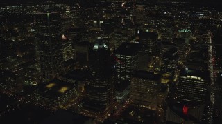 AX155_329 - 5.5K aerial stock footage flying over KOIN Center and Wells Fargo Center, and reveal city squares at night in Downtown Portland, Oregon