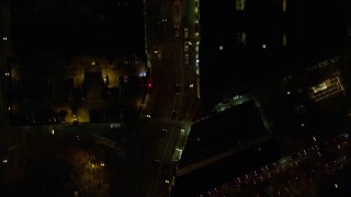 AX155_350E - 5.5K aerial stock footage of a bird's eye of dark streets and SW Broadway in downtown at nighttime, reveal Pioneer Courthouse Square Downtown Portland, Oregon