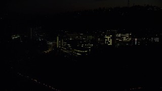 AX155_358 - 5.5K aerial stock footage flying by and away from the Oregon Health and Science University at night in Portland, Oregon