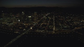 AX155_362 - 5.5K stock footage aerial video of US Bancorp Tower and White Stag sign across the Willamette River, Burnside Bridge and Steel Bridge, night, Downtown Portland, Oregon