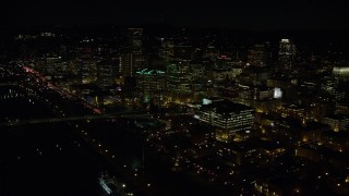 AX155_370E - 5.5K aerial stock footage of Downtown Portland at night, and reveal the White Stag sign, Oregon