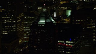AX155_375E - 5.5K aerial stock footage of KOIN Center rooftop venting steam at night in Downtown Portland, Oregon