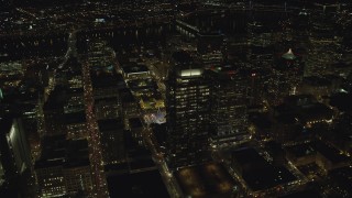 AX155_403 - 5.5K stock footage aerial video flying over skyscrapers to reveal Christmas tree in Pioneer Courthouse Square at night in Downtown Portland, Oregon