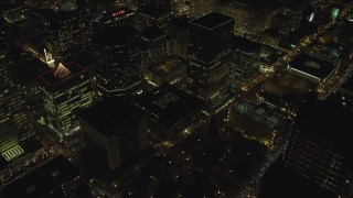 AX155_405 - 5.5K aerial stock footage flying away from downtown buildings at night in Downtown Portland, Oregon, reveal KOIN Center