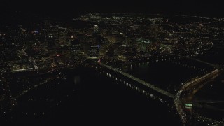 AX155_406 - 5.5K aerial stock footage flying by and approaching Downtown Portland from the Hawthorne Bridge at night, Oregon