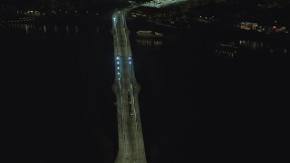 AX155_416 - 5.5K stock footage aerial video orbiting Tilikum Crossing bridge as a commuter train crosses the span at night in South Portland, Oregon