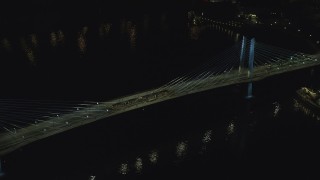 AX155_417 - 5.5K stock footage aerial video tracking commuter trains crossing the Tilikum Crossing bridge at night in South Portland, Oregon