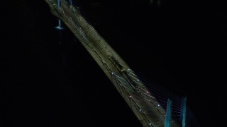AX155_418 - 5.5K stock footage aerial video tracking and a reverse view of a commuter train crossing the Tilikum Crossing bridge at night in South Portland, Oregon