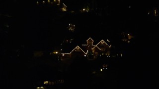 AX155_442 - 5.5K aerial stock footage approaching a suburban home at night decorated for Christmas, Southwest Portland, Oregon