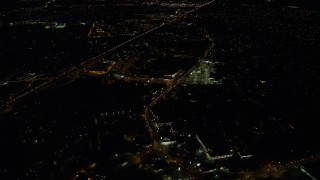 AX155_444E - 5.5K aerial stock footage flying over apartment complex toward strip malls and suburban homes by Highway 26 at night, Beaverton, Oregon